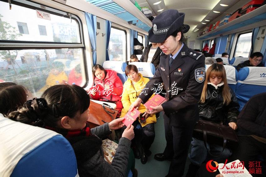 12月4日乘警在車廂內(nèi)向旅客免費發(fā)放《中華人民共和國憲法》。韋士釗 攝